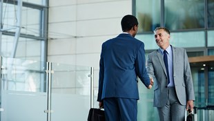 Two men in suits shaking hands