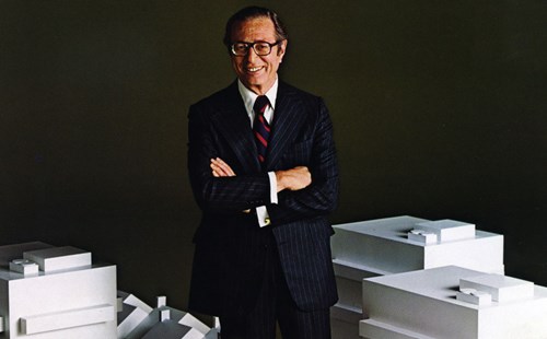 Max Karl, MGIC Founder, stands over model buildings and houses