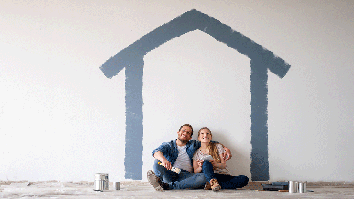 happy couple with painted outline of house
